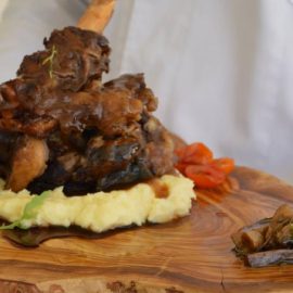 Χοιρινό κότσι Ελληνικού μαύρου χοίρου με μανιτάρια τουρσί και πουρέ πατάτας με ανθόγαλο και γραβιέρα
